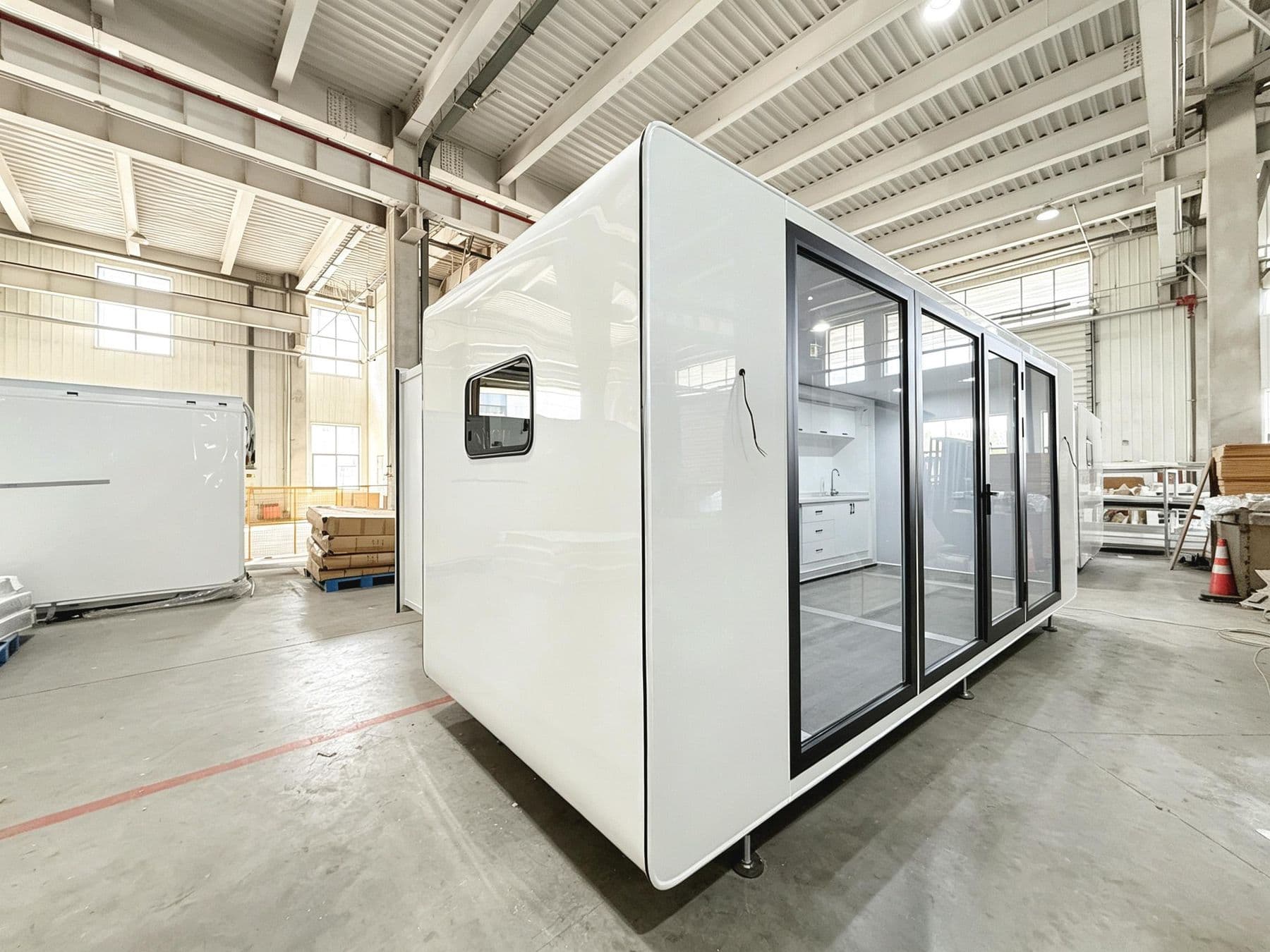 X3 Expandable in white with a full-height glass wall, in the factory